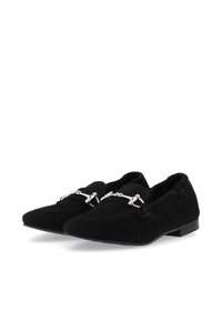 Mocasines de ante negros con punta afilada, que presentan un herraje plateado en la parte delantera y una suela plana y minimalista.