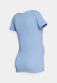 Top azul claro, de mangas curtas, com uma superfície texturizada e ligeiras mangas bufantes; decote redondo simples, forma ajustada.