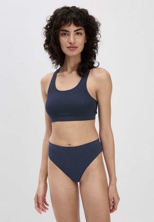 Marineblauwe geribbelde sportbeha met een ontwerp van brede schouderbanden en bijpassende high-waisted bikinitop. Gladde textuur, minimale naden, zonder padding.
