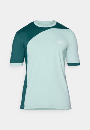 Trumpai rankovėmis sportinė marškinėlė šviesiai mėtų ir tamsiai žalia spalva. Yra lenkta dviejų spalvų dizainas, apvalus kaklas ir EA7 logotipas ant krūtinės.