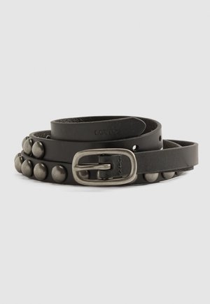 Ceinture en cuir noir enroulée avec des clous métalliques le long d'un bord et une boucle rectangulaire en argent antique.