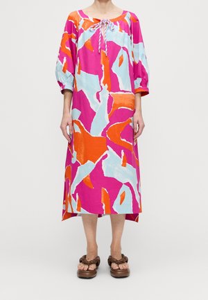 Robe colorée et à motifs avec des nuances de rose, bleu et orange. Présente une coupe ample, des manches bouffantes et un détail de nœud au niveau du col.