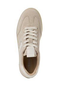 Beżowe zamszowe sneakersy z kremowymi płaskimi sznurówkami, wyściełanym językiem i białymi akcentami. Podeszwa jest jasnobeżowa z gładką teksturą.