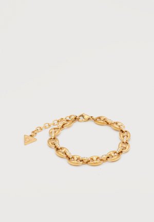 Bracelet chaîne en or avec des maillons ovales, chaque maillon orné de petits cristaux, doté d'un fermoir ajustable et d'une médaille triangulaire.