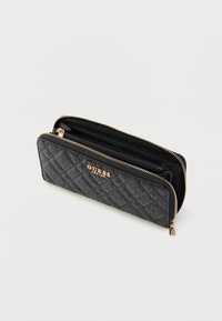 Czarny pikowany portfel ze złotym okuciem. Posiada zamek błyskawiczny oraz kilka przegródek na karty i monety. Logo marki wyraźnie widoczne.