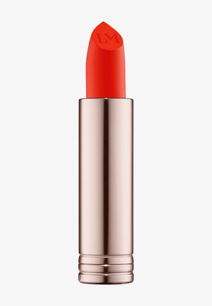 Red lipstick in a metallic rose gold tube, featuring a distinctive pointed tip with the initials "LM" embossed on it.
