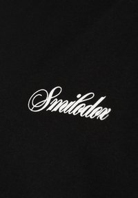 Schwarzer Stoff mit weißem kursiv geschriebenem Text „Smilodox“, mittig auf der Oberfläche platziert.