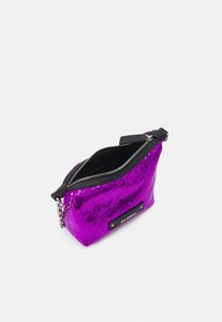 Fioletowa torebka z cekinami, wyposażona w czarny zamek błyskawiczny i skórzane akcenty. Posiada łańcuszkowy detal oraz gładką podszewkę. Kompaktowy design.