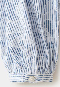 Manche de chemise rayée bleu et blanc avec un poignet boutonné et un subtil motif floral brodé blanc.