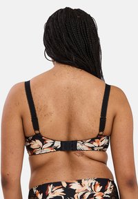 Reggiseno nero floreale con spalline larghe, ganci regolabili e bordi sfilati, caratterizzato da motivi arancioni e crema su uno sfondo scuro.