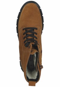 Botte cheville en suède marron avec lacets noirs, une fermeture éclair, semelle en caoutchouc et doublure douce ; possède un bout arrondi et des surpiqûres contrastées.