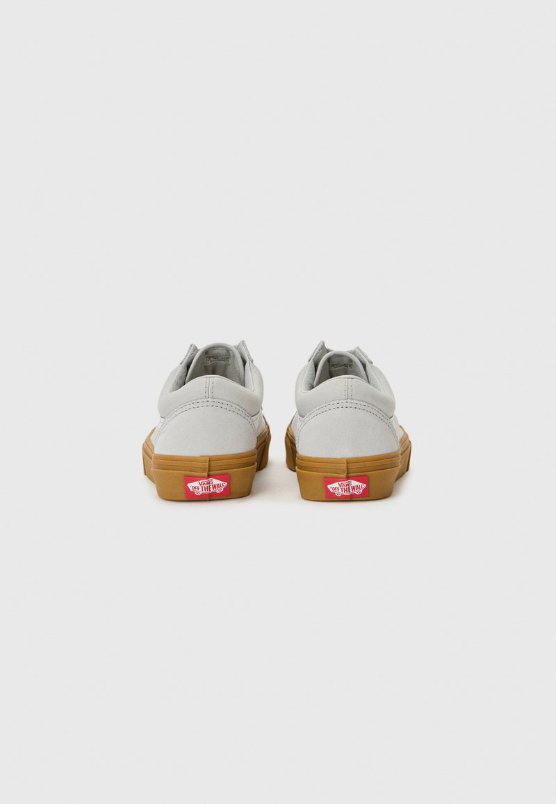 Graue Wildledersneaker mit einer braunen Gummisohle. Verfügt über einen gepolsterten Kragen, ein kontrastierendes rotes Logo-Label an der Ferse und flache Schnürsenkel.