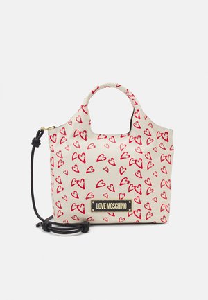 Cremefarbene Handtasche mit handgezeichneten roten Herzen, schwarzem verstellbarem Träger und goldakzentuierter "Love Moschino" Logo-Plakette auf der Vorderseite.