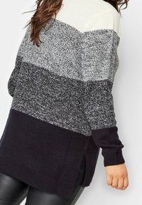 Stickad tröja med en trefärgad design i kräm, grå och marinblå. Långa ärmar, ribbade muddarna och side slits vid fållen.