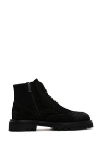 Botines de ante negro con cordones en la parte delantera, cierre de cremallera, detalles decorativos de ojales y una suela de goma gruesa.