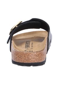 Sandalo nero con suola in sughero, plantare testurizzato, fibbia dorata e design del cinturino curvato. Suola in gomma resistente per una buona trazione.