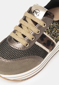 Sneaker z szarymi i czarnymi teksturowanymi materiałami, akcentami ze złotego brokatu, detalem w panterkę oraz metalowymi złotymi elementami na języku.