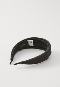 Black fabric headband with a smooth texture, curved shape, and small size tag visible, designed for easy wear and comfort.