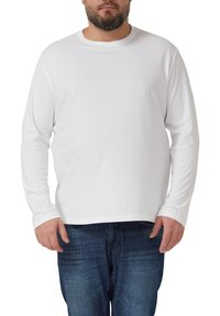 Langärmeliges weißes T-Shirt aus Baumwolle mit Rundhalsausschnitt und lockerem Schnitt. Trägt man zu blauen Jeans.