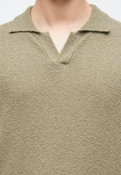 Πλεκτό πουλόβερ σε ελιά πράσινο, με υφή, V-λαιμόκοψη και κλασικό γιακά. Μαλακό, ελαφρύ ύφασμα.