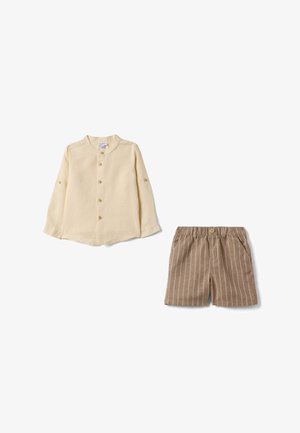 Camisa de manga larga color crema con cuello mandarín y pantalones cortos beige a rayas con cintura elástica y botón frontal.