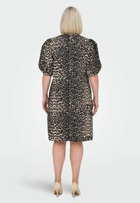 Klänning med leopardtryck som har en avslappnad passform, korta puffärmar och knälång design. Tillverkad av lätt tyg med fickor.