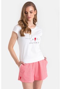 Biała koszulka z napisem "kochaj siebie" czarnym, ozdobnym pismem oraz czerwoną serduszkiem, w zestawie z szortami w biało-czerwone kratę z małym czerwonym akcentem w kształcie serca.