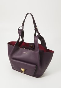 Lilla læder tote taske med robust design, struktureret yderside, rød indre, der har en frontlomme med en gylden lås og logo.