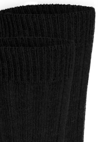 Schwarze gestrickte Socken mit einem gerippten Muster, die ein dickes Bündchen und einen glatten Schaft aufweisen. Das Material wirkt weich und flexibel.