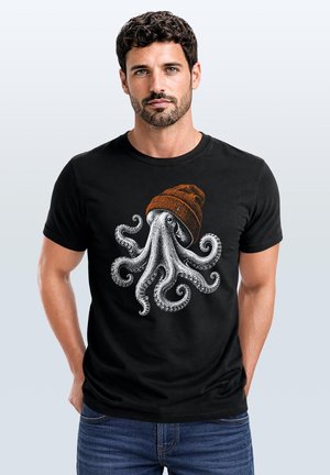 Man with curly hair and beard wearing a black t-shirt featuring a detailed octopus graphic wearing a brown beanie hat.