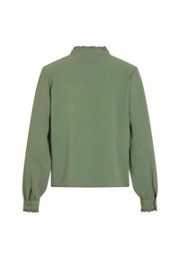Grüne Bluse mit Rüsche am Kragen und an den Ärmelbündchen, langen Ärmeln und strukturiertem Stoff. Schlichte Rückansicht, cropped Länge mit Seitenschlitzen.