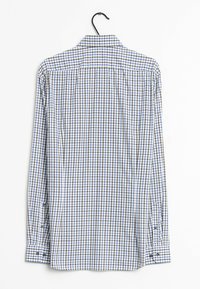 Camicia a maniche lunghe a scacchi in tonalità blu, bianco e marrone; polsini con bottone; colletto classico; tessuto di cotone liscio; appesa a un gancio.