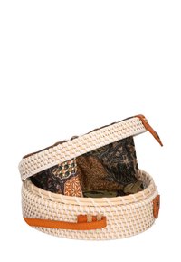 Cestino intrecciato rotondo realizzato in fibre naturali con un esterno beige; presenta una fodera in tessuto a motivi in toni terrosi e una chiusura con cinturino in pelle.