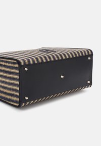 Woven straw and navy leather bag with a rectangular shape, featuring a striped pattern, silver hardware accents, and protective metal feet.