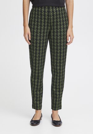 Black and green houndstooth pants with a slim fit, featuring a textured fabric and a smooth waistband, paired with black ballet flats.