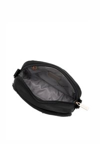 Czarna kosmetyczka na zamek błyskawiczny o gładkiej powierzchni, wyłożona wnętrze z powtarzającym się logo marki oraz złotymi akcentami.