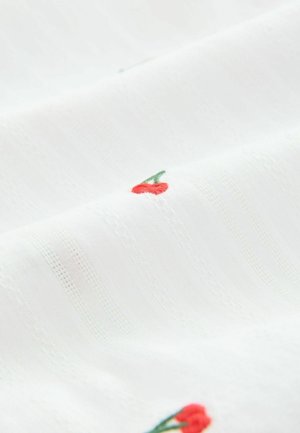 Fehér anyag, finom csíkozással és apró, piros cseresznye hímzéssel. Az anyag könnyűnek és simának tűnik.