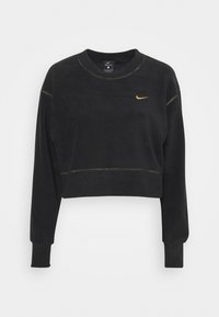 Schwarzes, kurzes Sweatshirt aus weichem Material. Mit langen Ärmeln, rundem Halsausschnitt und goldenem Nike-Logo auf der Brust. Sichtbare Kontrastnähte.