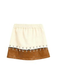 Falda mini beige y marrón con cintura elástica y detalles de cadena de metal a lo largo de la frontera entre los dos colores.