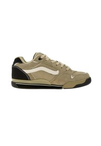 Zapatilla deportiva beige con materiales de ante y malla, presenta una franja de acento blanca, panel trasero negro y suela de goma texturizada.