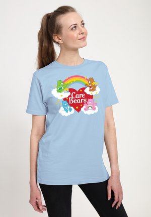 Lyseblå bomulds T-shirt med et farverigt Care Bears grafik med en regnbue, skyer og stjerner, centreret på forsiden.