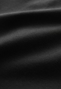 Tissu noir avec une finition lisse et texturée, présentant des lignes horizontales subtiles et une surface mate. Matériau doux et flexible.