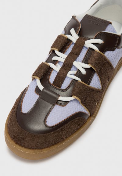 Adidași maro și albastru, cu texturi din plasă și piele întoarsă, cu accente din piele, un design unic al baretei și șireturi albe pe o talpă din cauciuc.