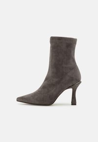 Szary zamszowy botek za kostkę z szpiczastym noskiem, wąskim wysokim obcasem, bezszwową konstrukcją i miękką fakturą. Klasyczny styl odpowiedni do różnych stylizacji.