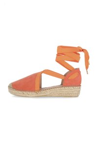 Pomarańczowe zamszowe espadryle z plecioną jutyową podeszwą i krzyżującymi się sznurkami wokół kostki, z wycięciami po bokach dla lepszej wentylacji.