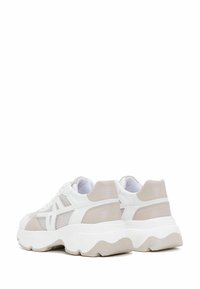 White and light beige sneakers with mesh and leather materials, chunky sole, and decorative stitching. Distinctive wave pattern on sole.