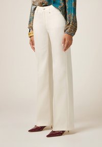 Wijdvallende witte broek van gladde katoenafwerking, met een klassieke vijf-pocket design en een hoge taille. Accenten van metalen knopen.