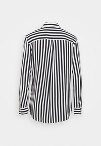 Camicia a maniche lunghe a strisce nero e bianco con colletto, dettaglio della piega sul retro e polsini abbottonati. Tessuto dalla texture liscia.