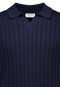 Granatowy sweter polo z dzianiny z teksturowanymi pionowymi paskami i kołnierzem o luźnym kroju, z etykietą "LINDBERGH" wewnątrz dekoltu.
