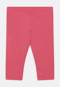 Rozā kokvilnas legingi ar gludu tekstūru. Iezīmējas ar pieguļošu dizainu, elastīgu jostasvietu un apdarinātām piedurknēm. Nav papildu rakstu vai akcentu.